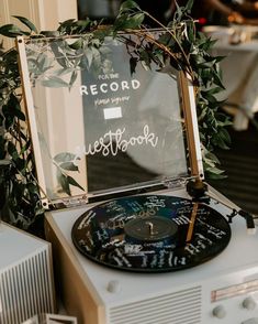 an old record player sitting on top of a table next to a mirror with writing on it