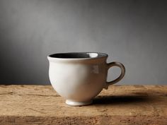 a white cup sitting on top of a wooden table