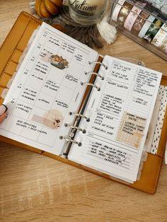 an open planner book sitting on top of a wooden table