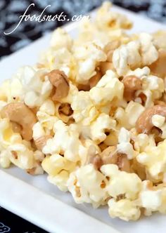 a white plate topped with popcorn covered in nuts