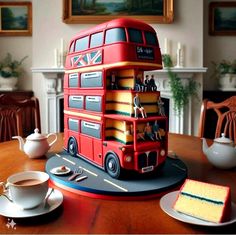 a cake made to look like a double decker bus is sitting on a table next to a cup and saucer