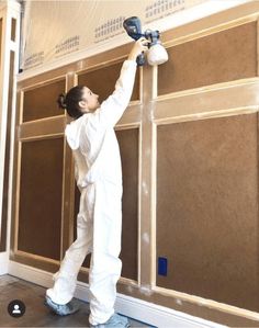 a woman is painting the walls in her home