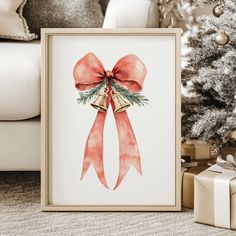 a christmas card with a red bow and bells on it next to a christmas tree