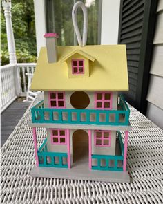 a doll house sitting on top of a white table next to a window and door