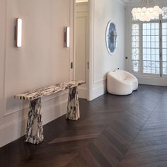 a white room with wood flooring and two benches in front of the doorways