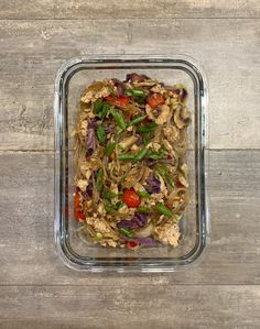 a glass container filled with food on top of a wooden table