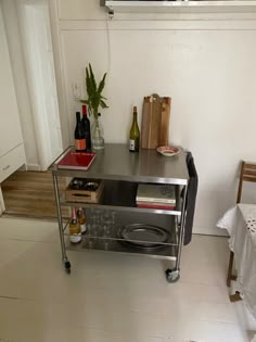 a small kitchen with a microwave on the counter and wine bottles on the table next to it