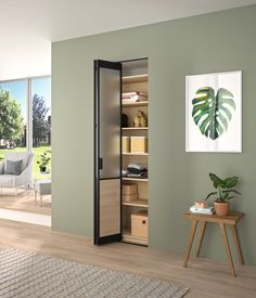 a living room with green walls and a wooden table in front of the open door