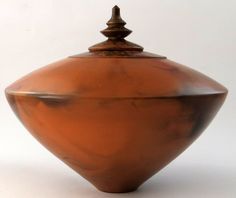 a brown vase sitting on top of a white table