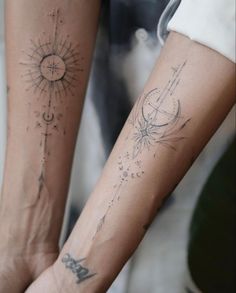 two people with tattoos on their arms and one is holding the other's hand