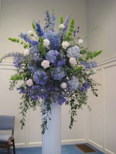 a white vase filled with blue and white flowers