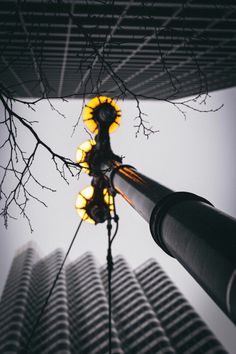 a street light with yellow lights on it in front of some tall building's