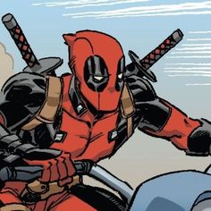 a man in a deadpool costume riding a motorcycle with two swords on his shoulder