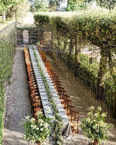 an outdoor dining area with tables and chairs set up in the center, surrounded by greenery