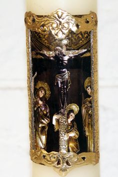 a lit candle with an image of the crucifix on it's side