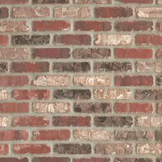 an old brick wall with red and brown bricks