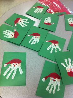 handprints on green paper with santa's hat