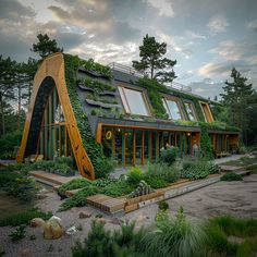 an unusual house with plants growing on the roof and side walls, surrounded by trees