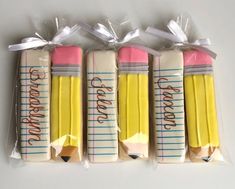 four pencils wrapped in cellophane and tied with ribbon on top of each other