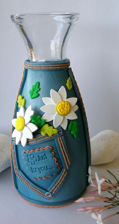 a blue vase with flowers in it sitting on a table next to some stuffed animals