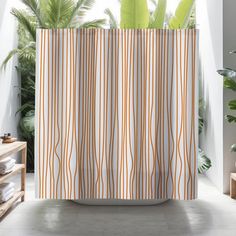 an orange and white striped shower curtain next to a potted plant in a bathroom