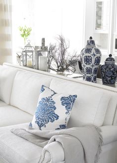 a white couch with blue and white pillows