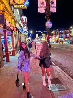 two girls walking down the street holding hands