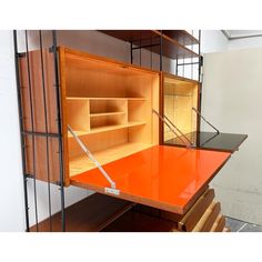 an orange desk with shelves and drawers on it