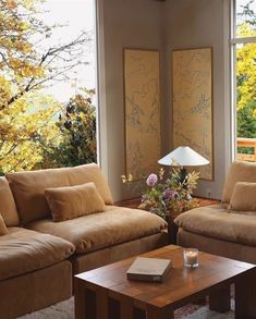 a living room with two couches and a coffee table in front of large windows