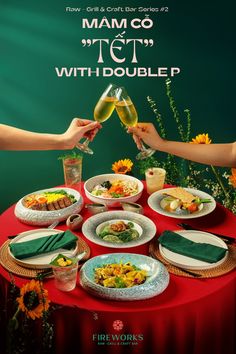 two people toasting wine glasses over a table full of food and drinks on it