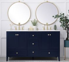 a bathroom with two round mirrors on the wall and a blue cabinet next to it