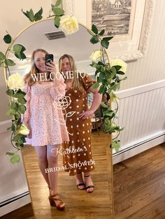 two women standing in front of a mirror