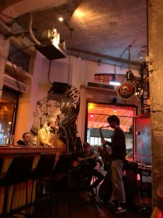 a man standing in front of a bar next to a tall vase with a skeleton on it