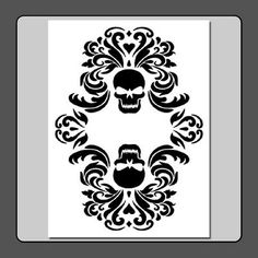 a white and black card with a skull in the center on a black satin background