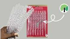 a hand holding a bunch of clear plastic beads in front of a package with the string attached