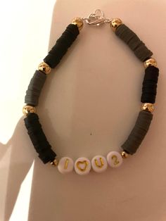 a black and gold beaded bracelet with the word i love you written on it