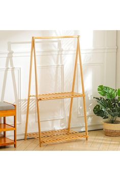 a wooden shelf sitting next to a potted plant