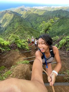 a woman is smiling as she walks up a steep hill with her legs spread out