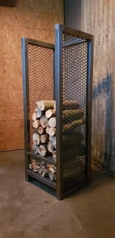 a stack of logs sitting inside of a metal container on top of a cement floor