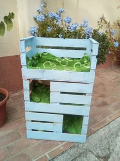 a planter made out of wooden pallets with plants growing in them on the ground