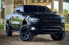 a black ram truck parked under a bridge