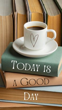 a cup of coffee sitting on top of two books with the words today is a good day