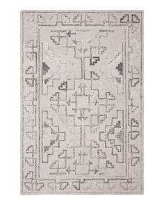 a gray and white rug with an intricate design on the bottom, in front of a white background