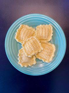 small crocheted pieces of bread on a blue plate