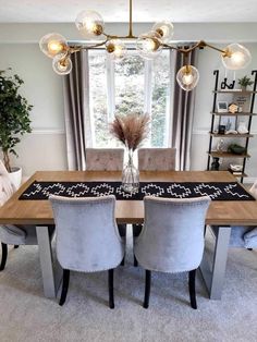 a dining room table with four chairs and a rug on the floor in front of it