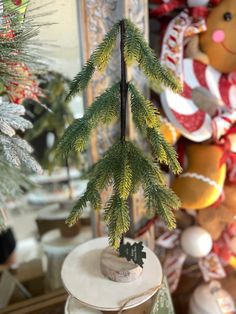 a small christmas tree sitting on top of a white plate next to a teddy bear