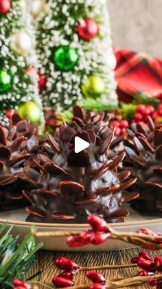 chocolate covered pine cones on a platter in front of christmas trees and other decorations