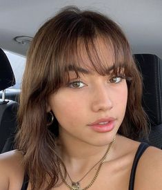 a young woman sitting in the back seat of a car with her hand on her hip