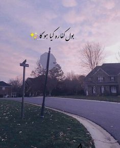 a street sign sitting on the side of a road in front of some houses and trees