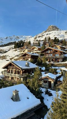 snow covered houses on the side of a mountain